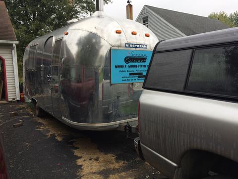 Photo of Airstream hooked up to pickup truck in driveway.